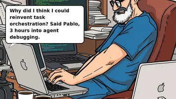 Bald middle-aged man in blue t-shirt and jeans, frustrated at laptop with coffee cups around, glasses low on nose.